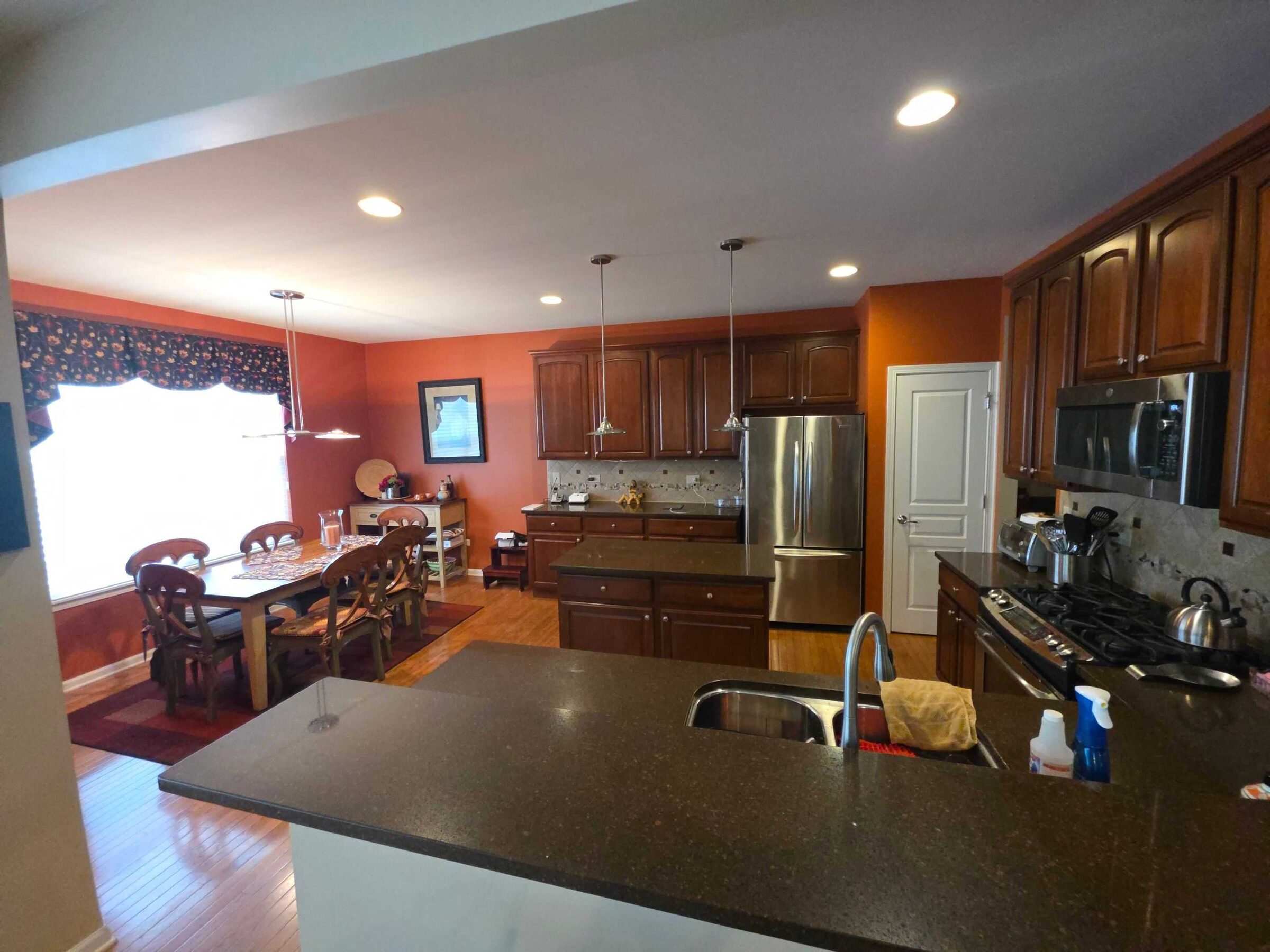 Before: the brown granite peninsula with the sink, looking toward the breakfast table