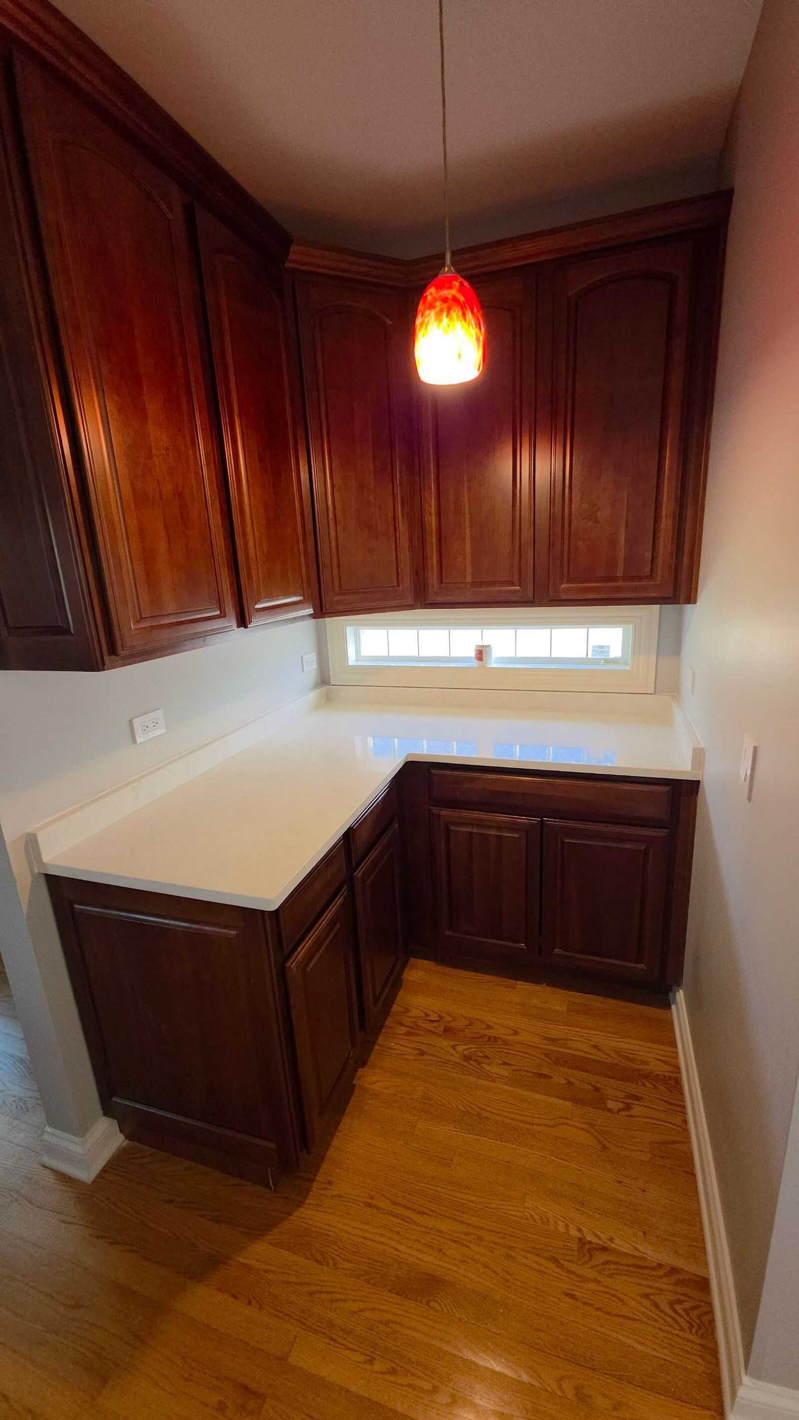 Quartz turning the corner into the window bay, cherry base cabinets below