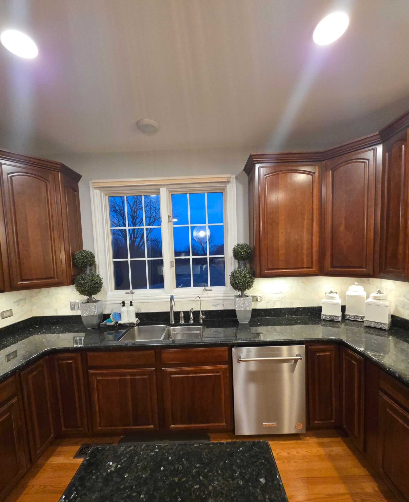 The old granite at the sink, its dark speckle set against a light tile backsplash