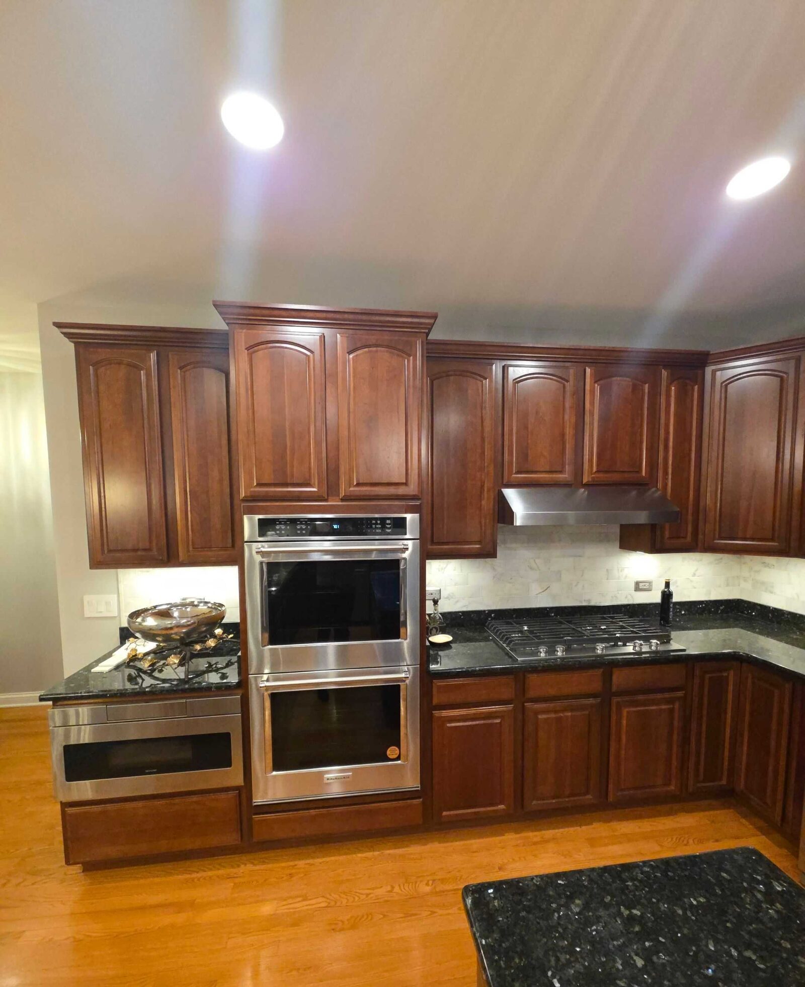 Before: the double wall ovens with dark granite counters either side