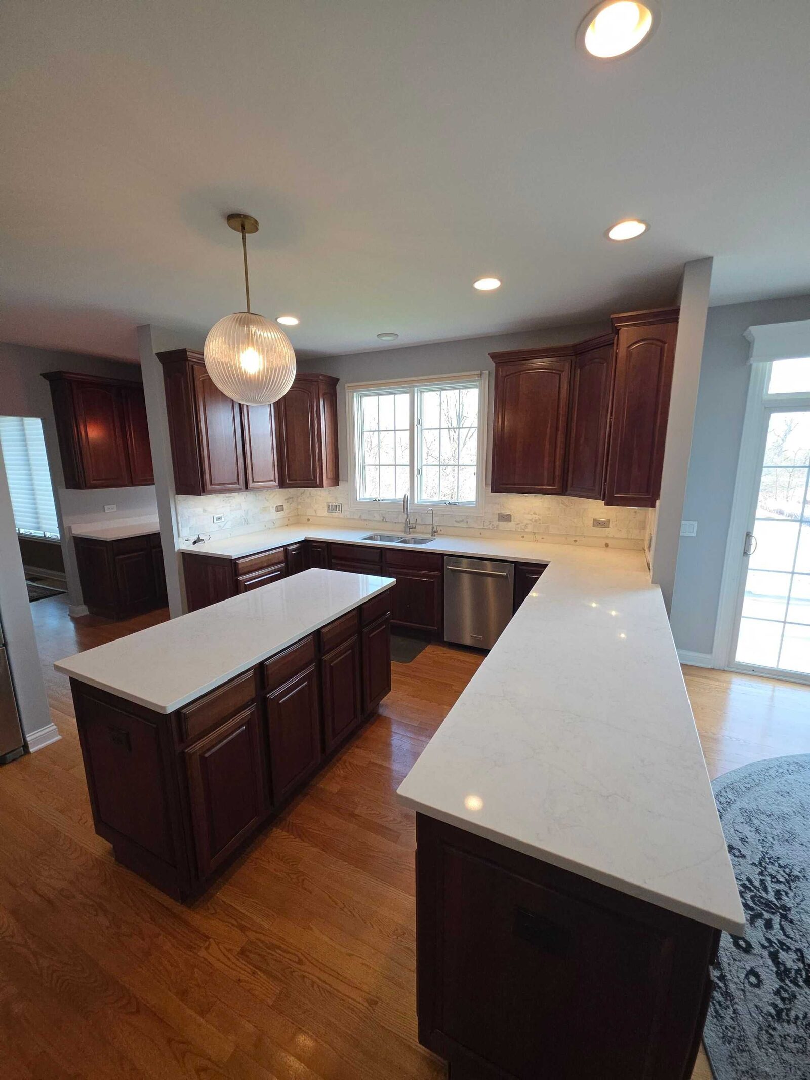 New white quartz at the sink and dishwasher, with the window run beyond