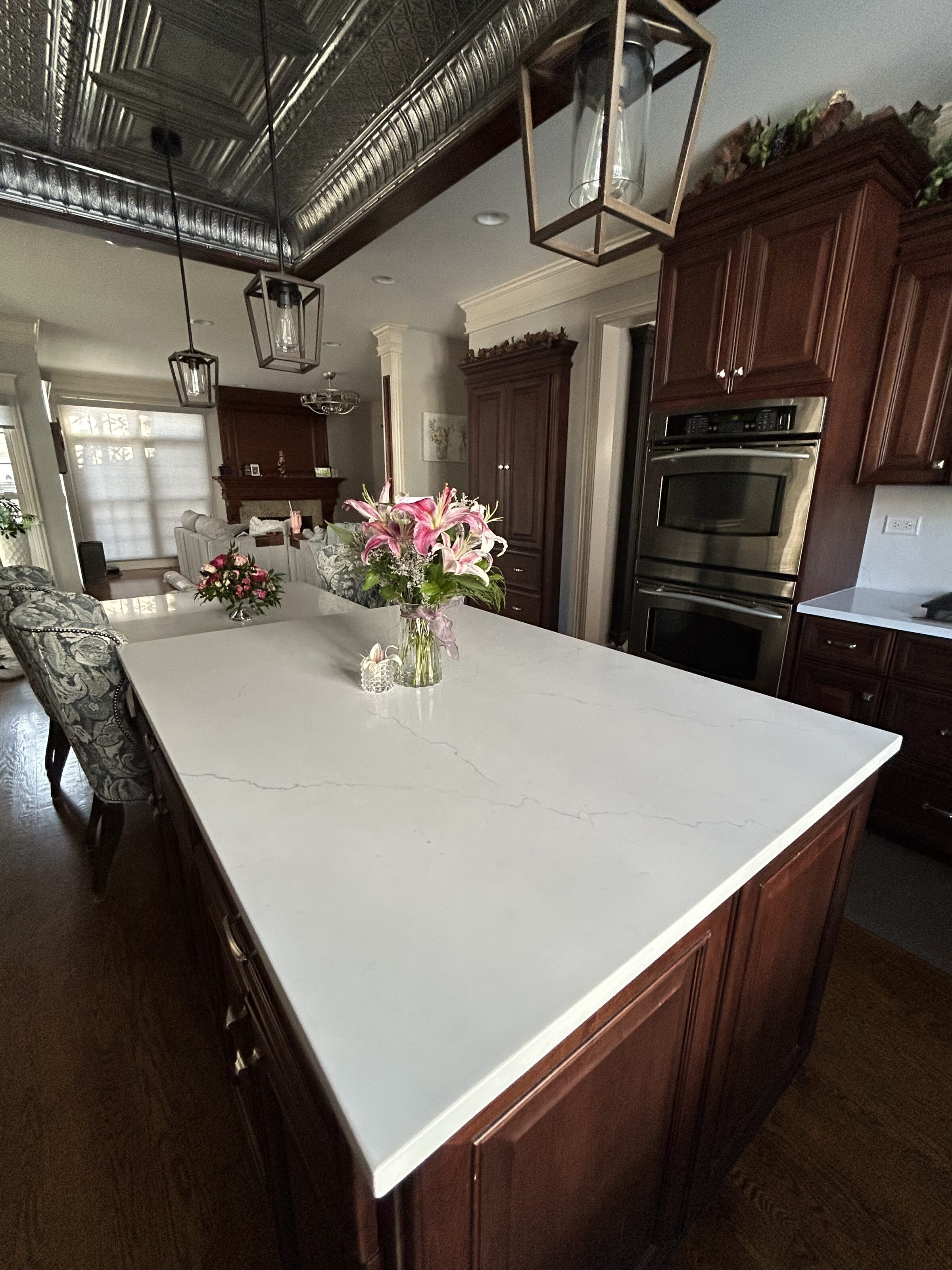 Quartz counter meeting the dishwasher and the cherry base cabinets on the sink wall