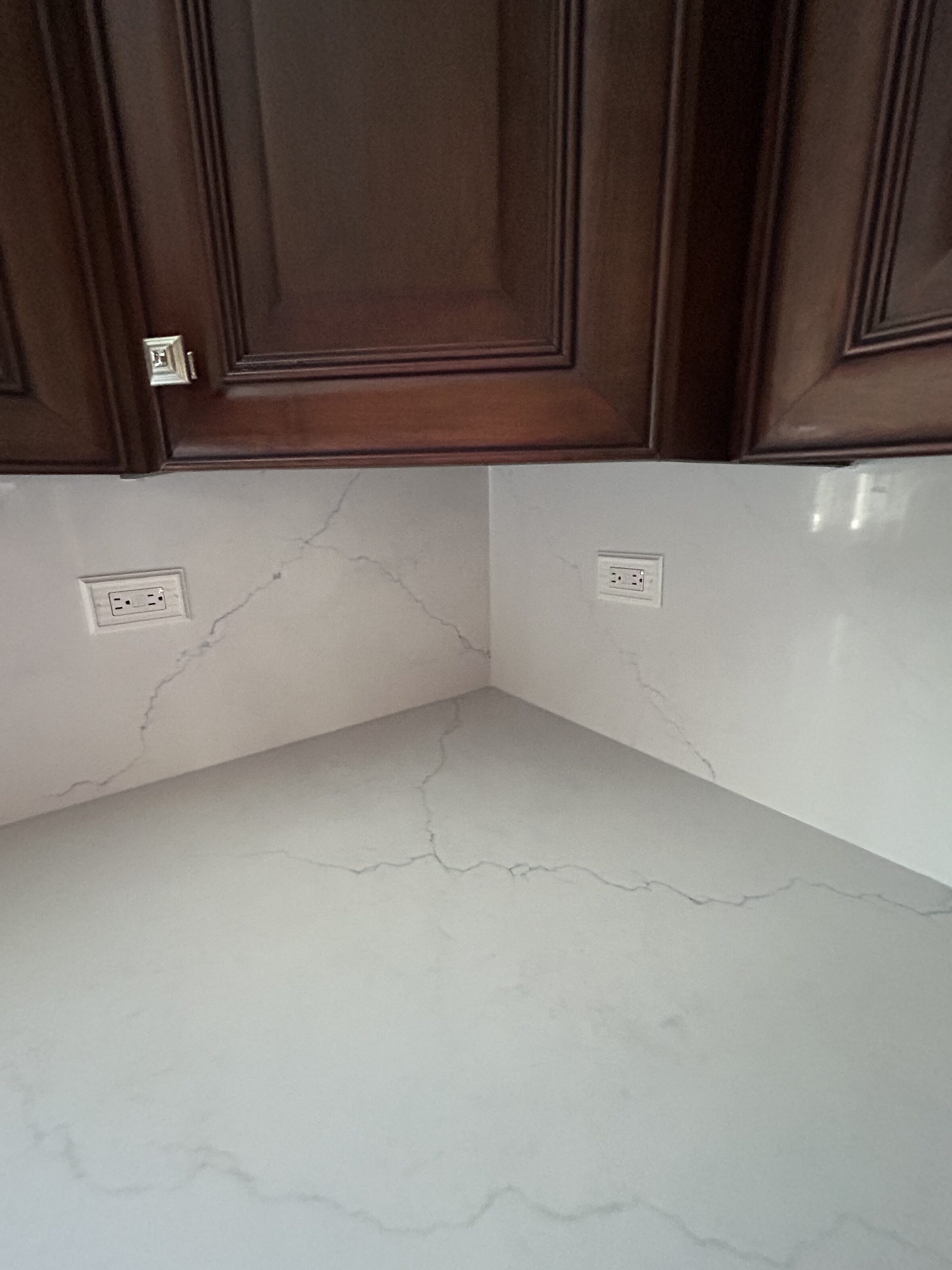 Close view of the quartz corner where two runs meet, showing how faint the veining reads at arm's length
