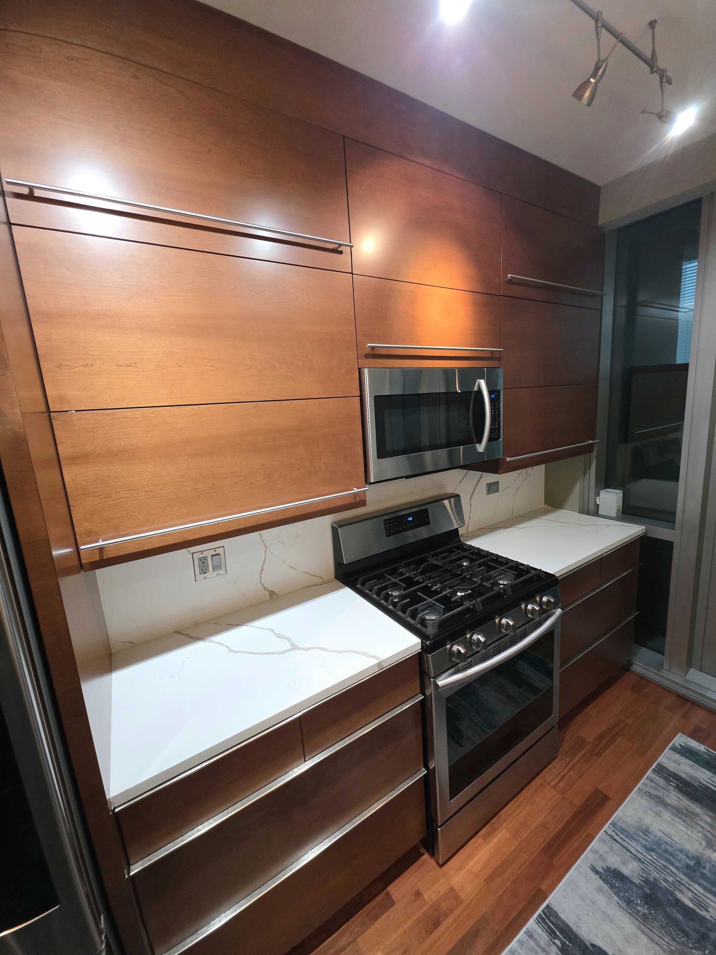 New white quartz either side of the range, against walnut slab cabinet fronts