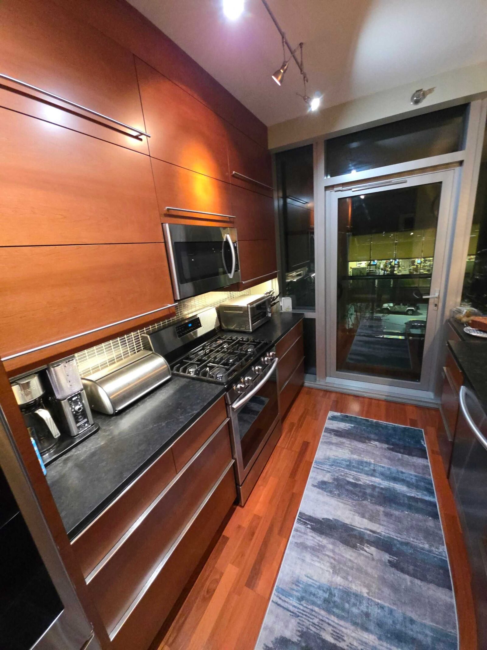 The old dark counter at the range, with a toaster oven and knife block along it