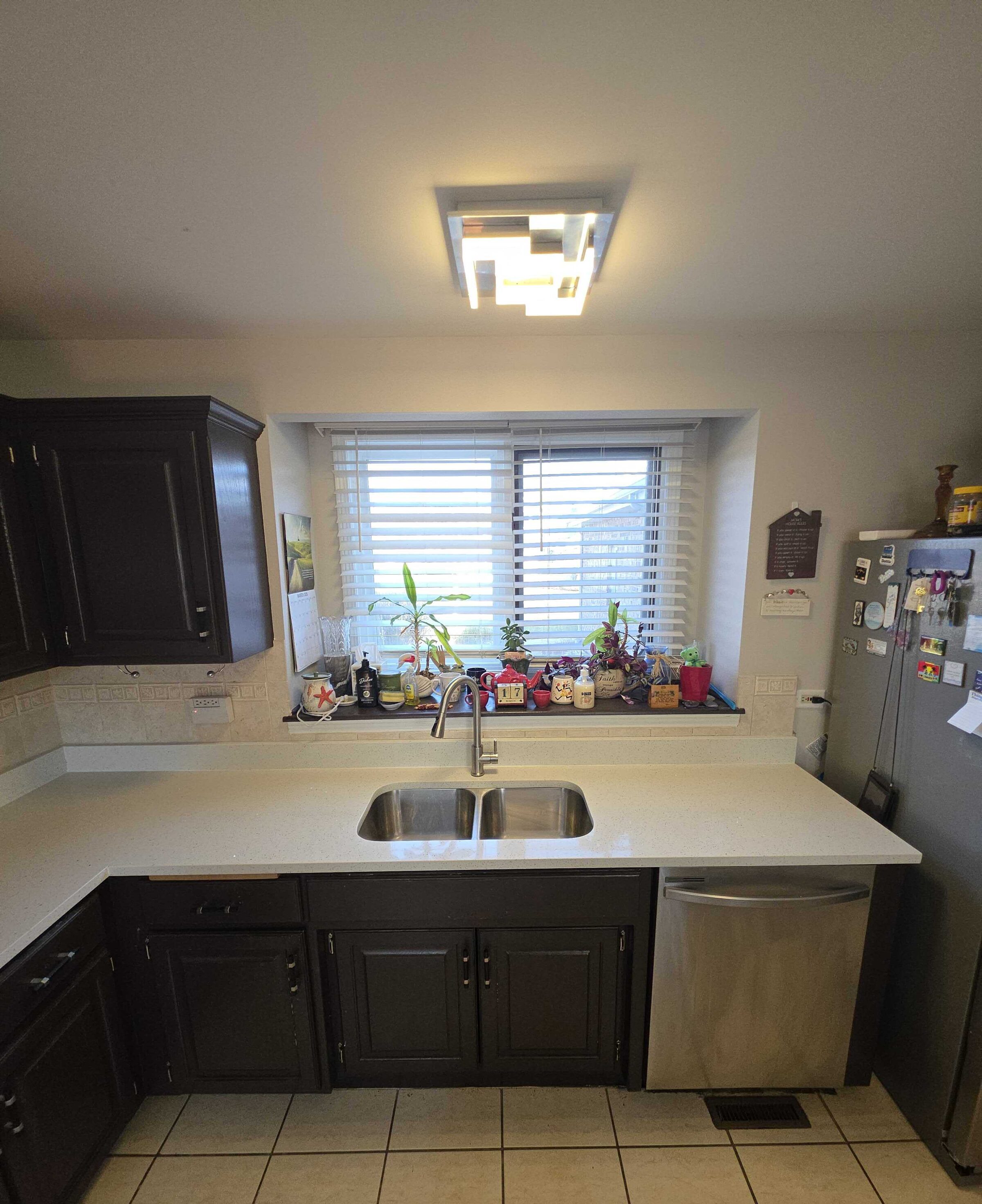 New quartz at the sink with a stainless double bowl and the dishwasher to the right