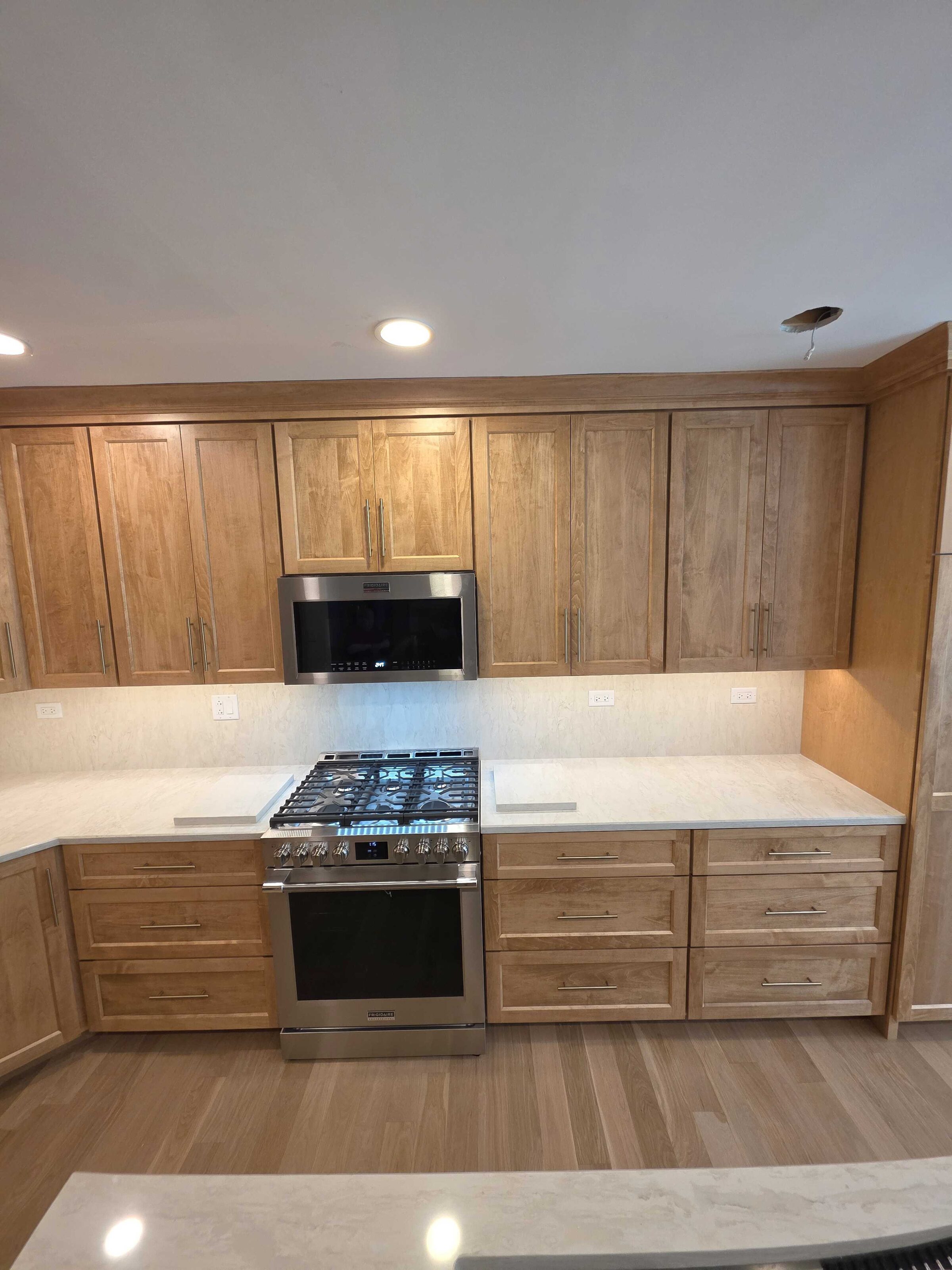 The finished range wall, cream quartz either side of a stainless slide-in range