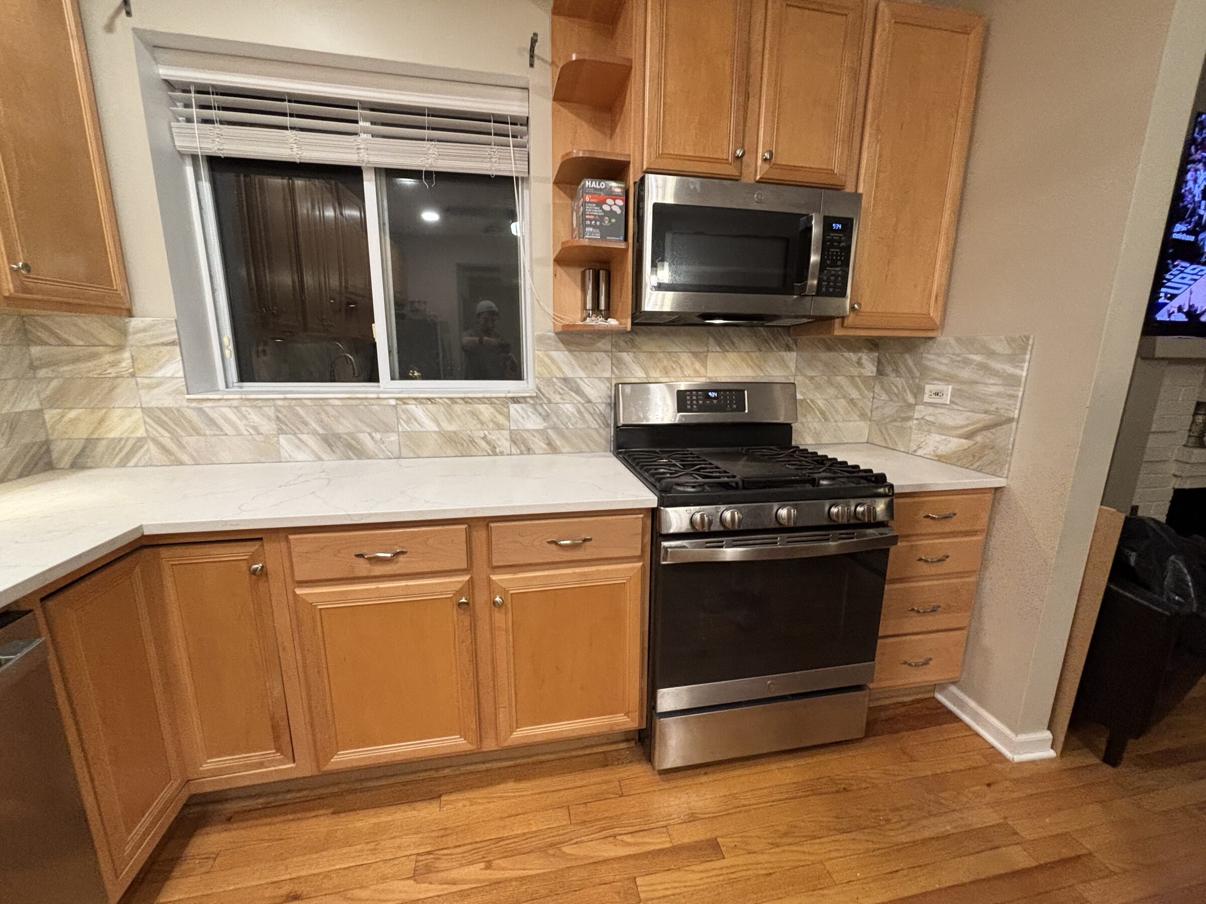 New quartz and stone backsplash carried up behind the stainless range
