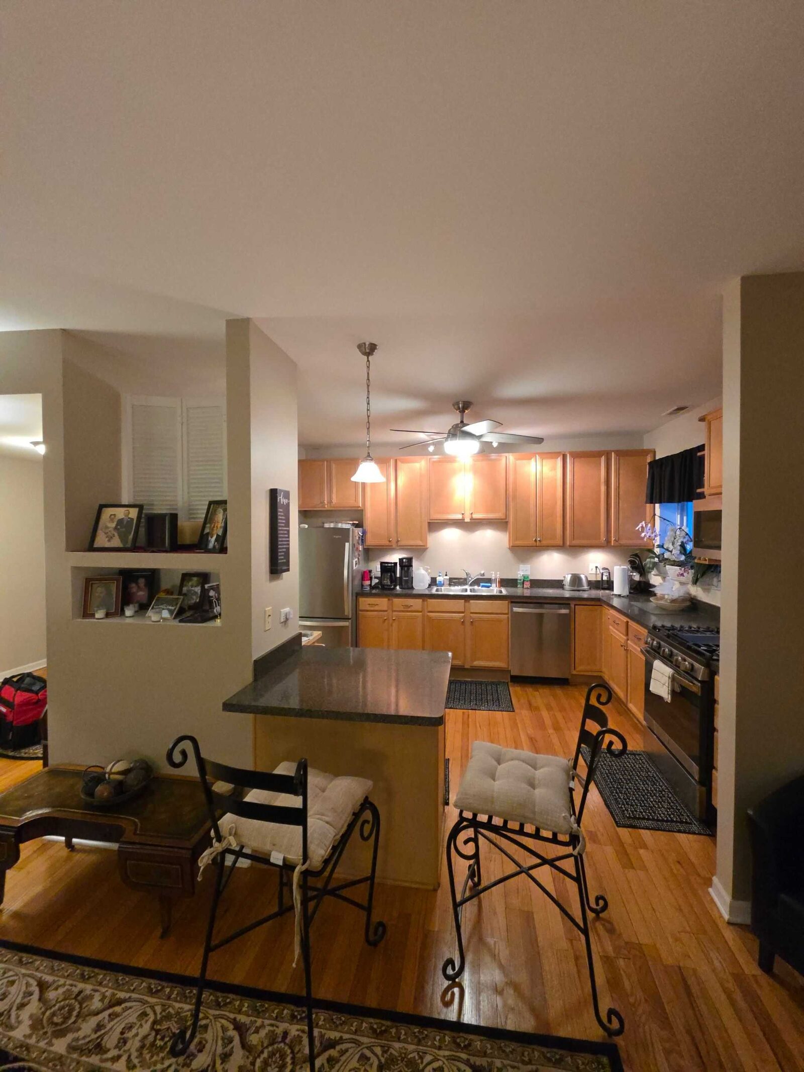 The kitchen before, dark counters on the peninsula and a bare wall behind the run