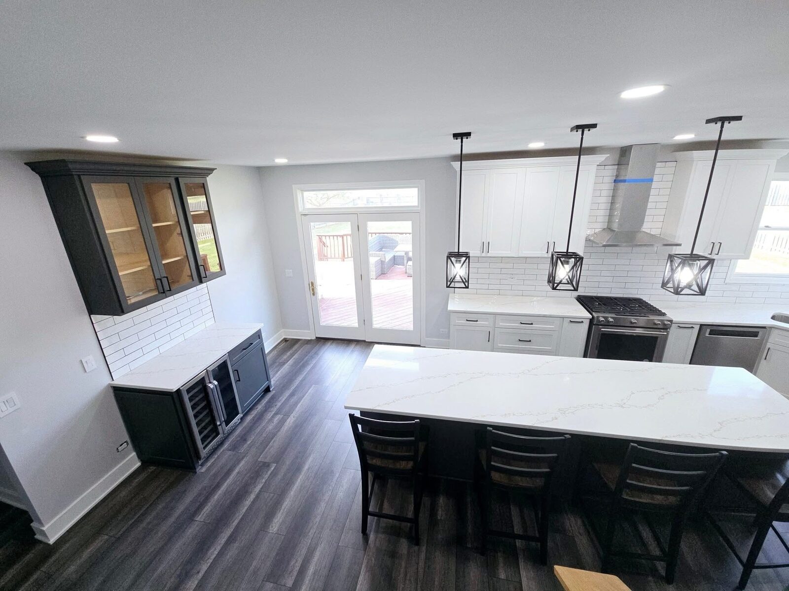 The island from the far corner, navy cabinetry and a wine fridge built into the end