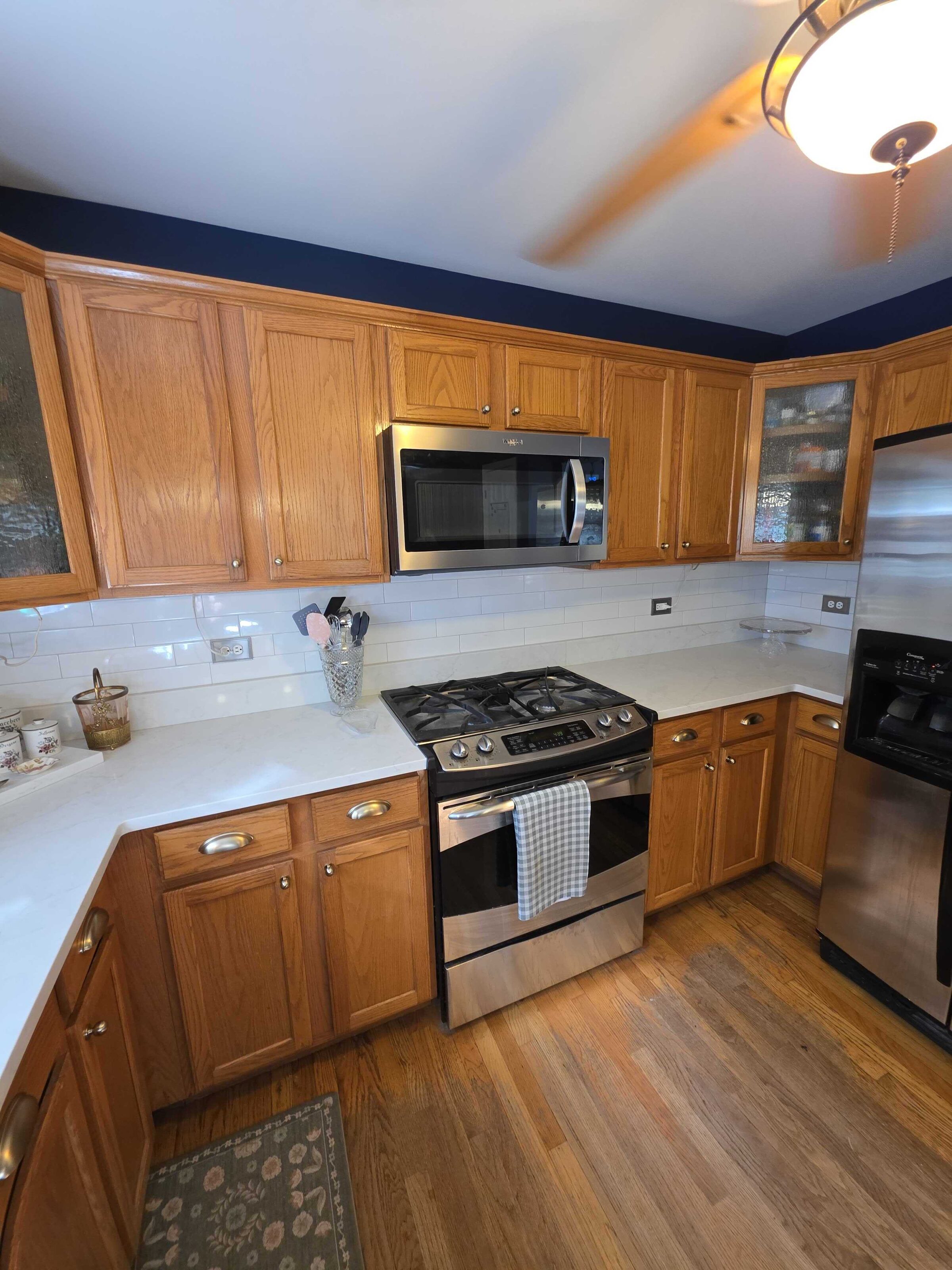 New white quartz either side of the stainless range, under oak uppers and a white subway backsplash