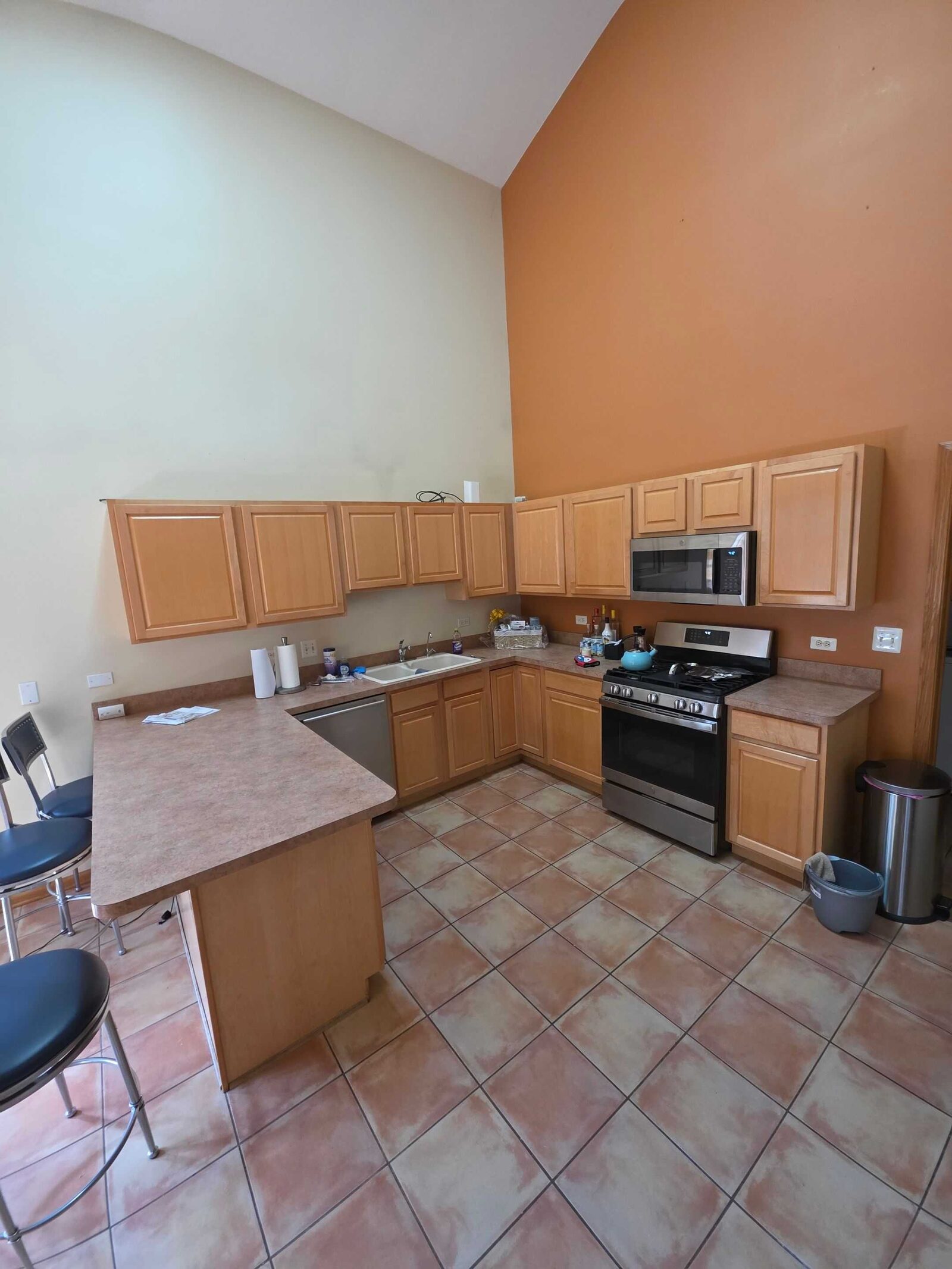 Before: the tan laminate U with the old sink and a paper-towel roll on the counter