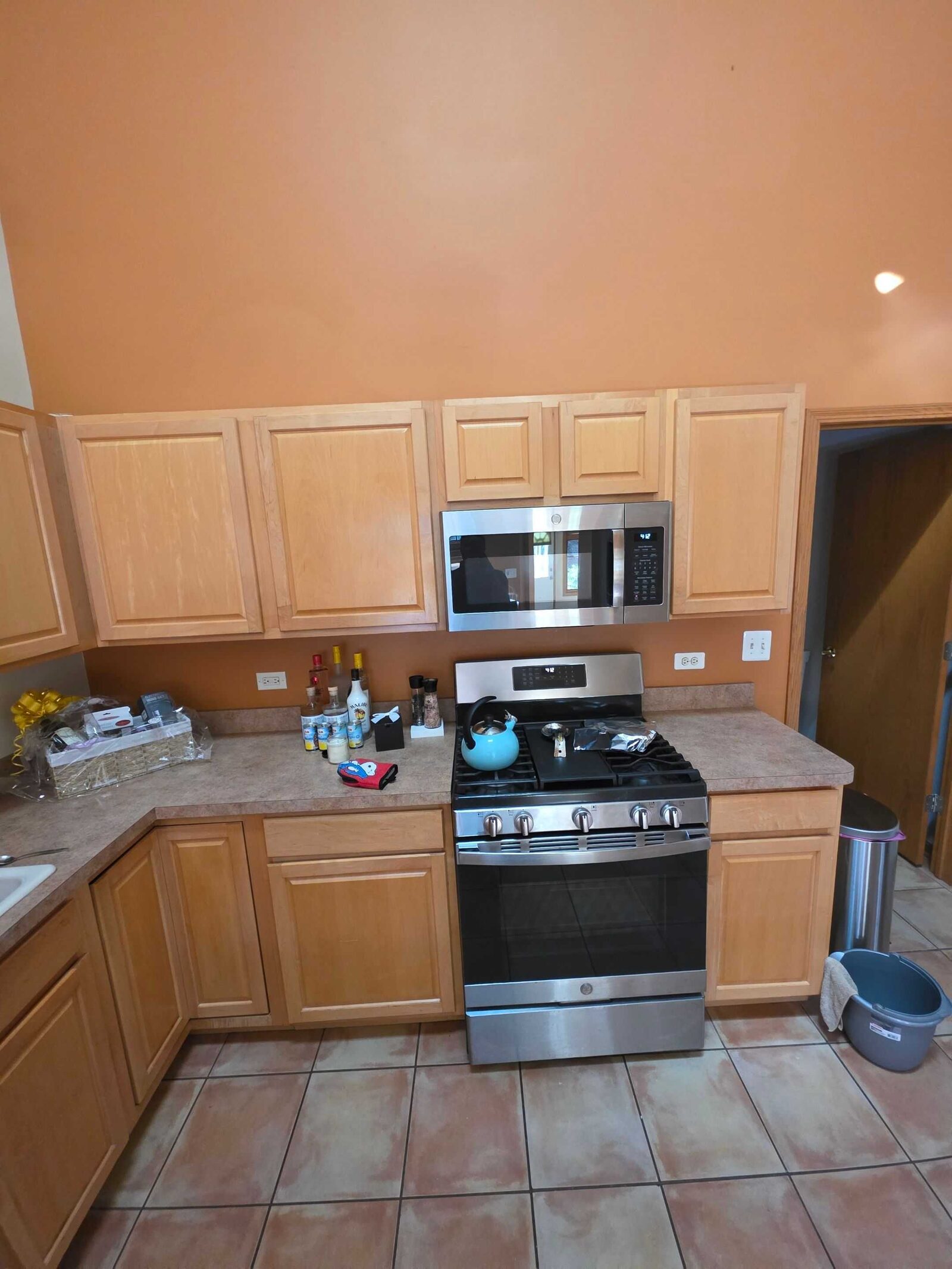 The identical view before, the range flanked by tan laminate and a cluttered counter