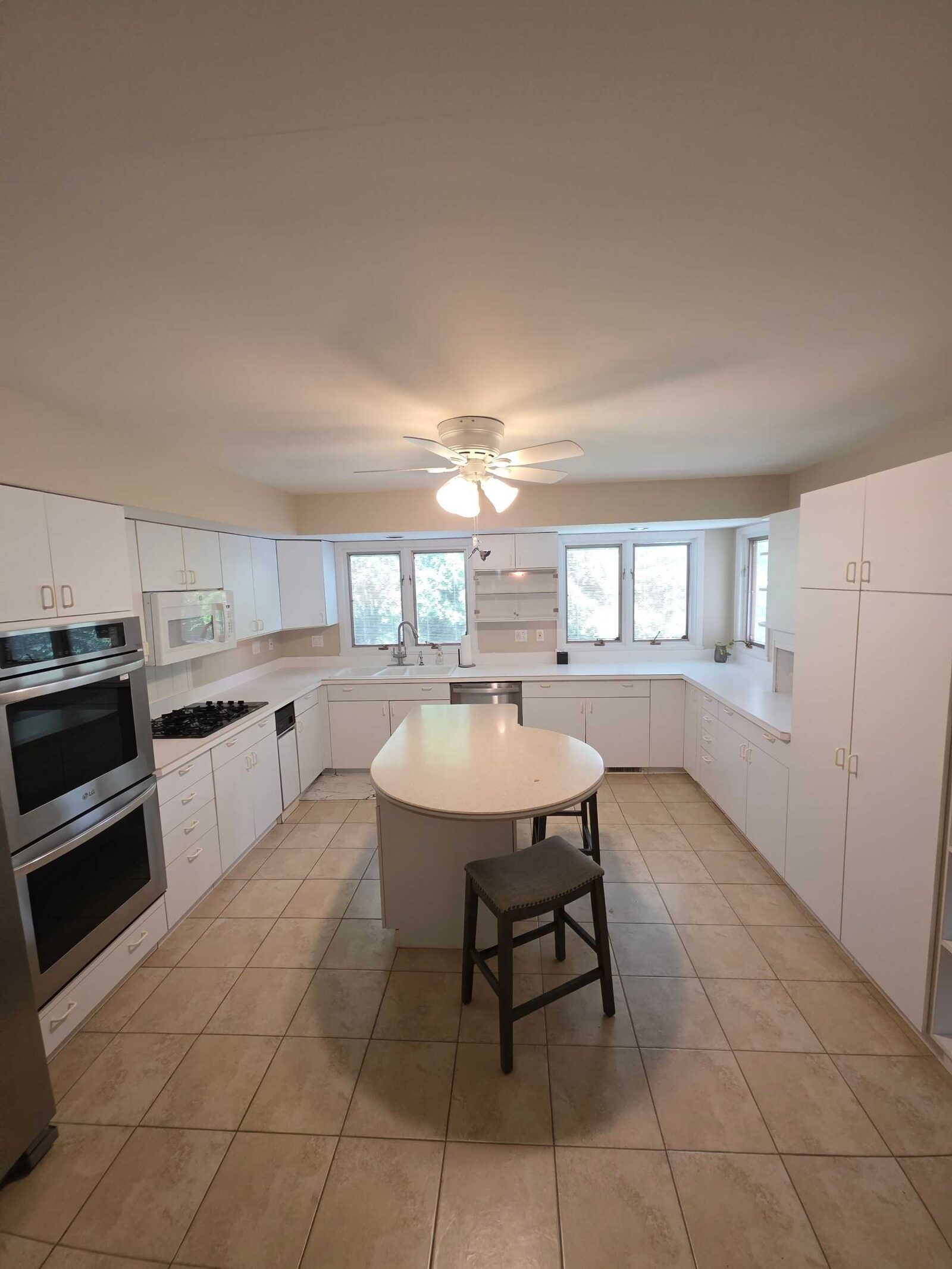 The same kitchen before, with plain white counters and an oval island