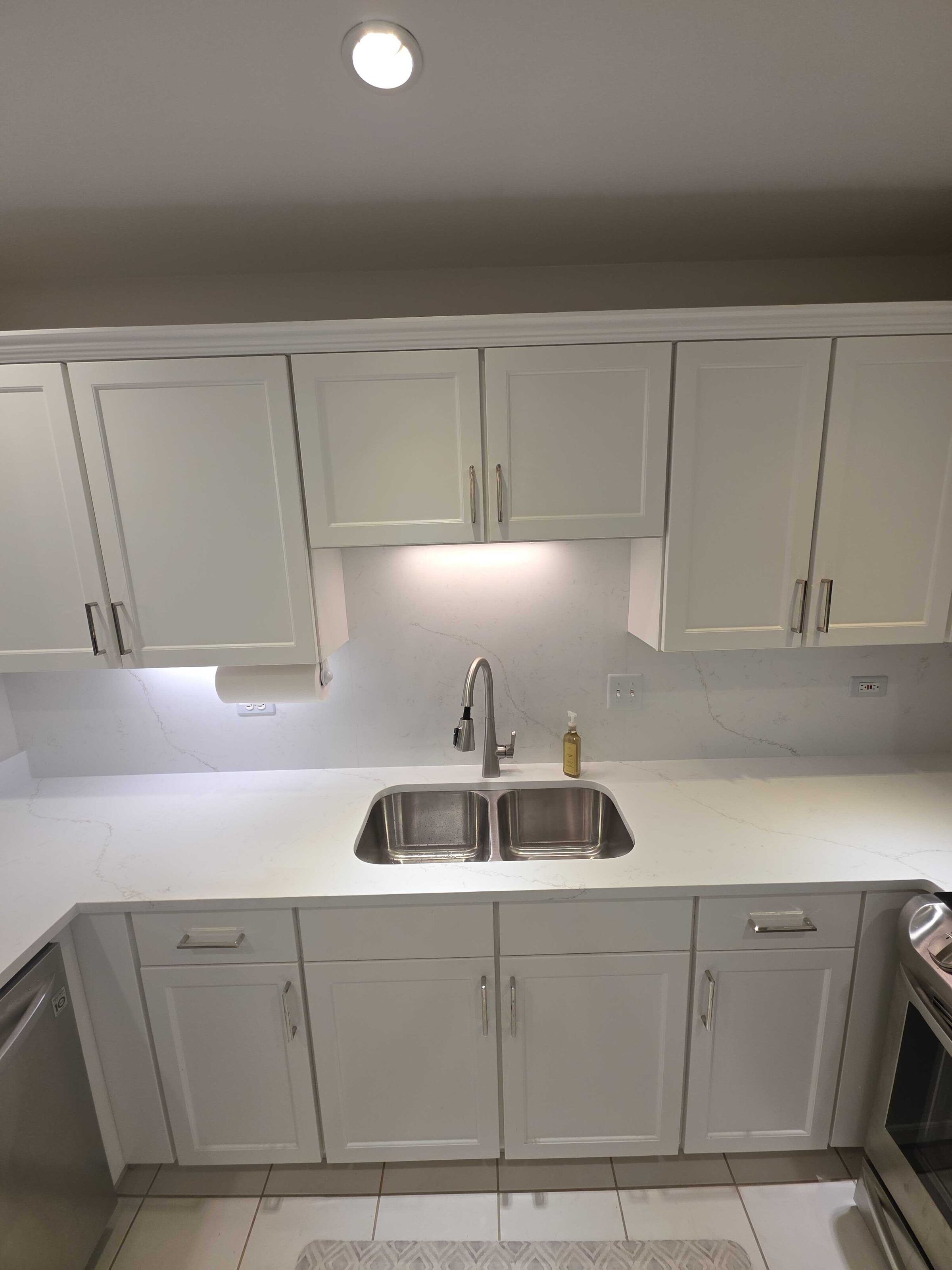 New quartz at the sink with a stainless double bowl and the run continuing past the dishwasher