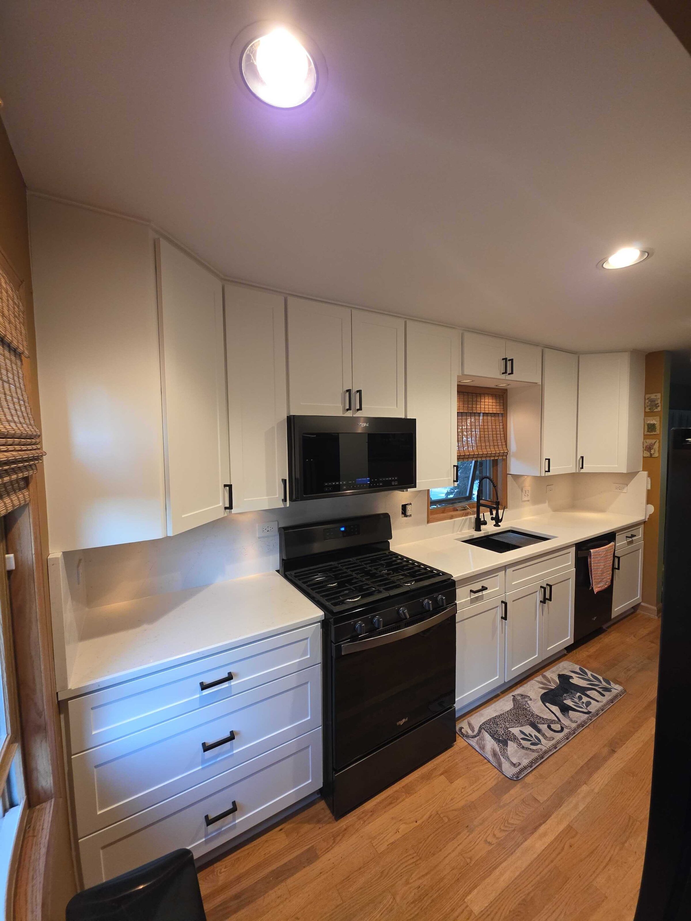 Finished white quartz running the length of the galley past the range and dishwasher